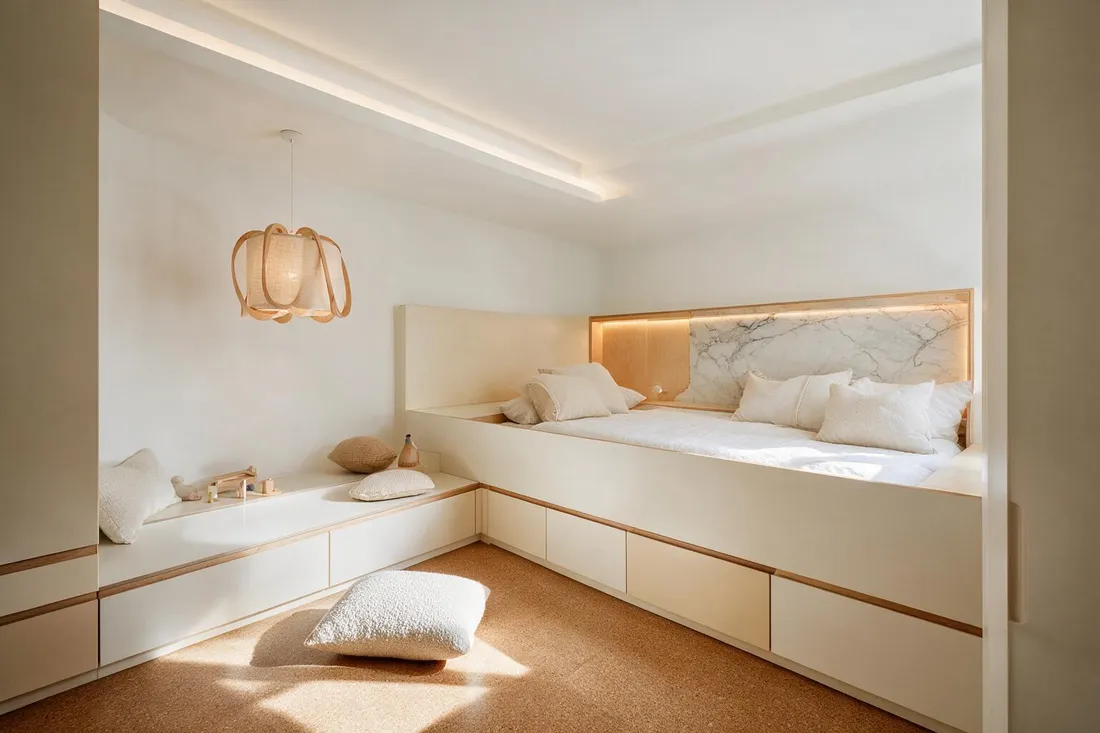 Warm Scandinavian children's bedroom with a built-in bed, lit birch-edged headboard niche and clay-toned storage wall
